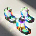 Three colorful crystal prisms casting vibrant rainbow reflections on a dark surface, showcasing their optical properties and decorative appeal.