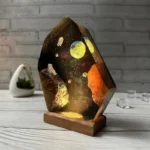 A stunning galaxy-themed resin lamp featuring vibrant colors and celestial designs, mounted on a wooden base, perfect for science decor and educational spaces.