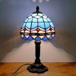 Elegant Tiffany-style stained glass table lamp featuring a colorful, intricate design and a classic black base, perfect for adding a touch of vintage charm to any space.
