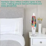 Colorful rainbow lamp emitting vibrant lights on bedside table in a cozy bedroom setting.