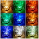 A glowing crystal cube emitting vibrant colors, displayed on a wooden surface with decorative plants and a small figurine. Perfect for science decor and educational toys.
