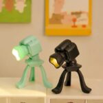 Small green and black LED desk lamps with adjustable tripod stands, ideal for science decor and educational setups.
