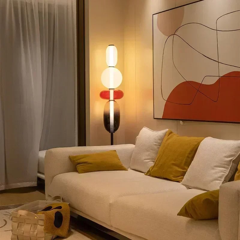 Modern living room with stylish decor and ambient lighting, featuring a cozy sofa with colorful cushions and contemporary artwork on the wall. Unique Living Room Table Lamp - Image 1