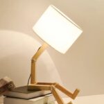 Adjustable wooden desk lamp with a white lampshade, designed to resemble a playful humanoid figure, perfect for a science-themed decor or educational space.