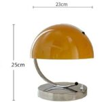 Amber desk lamp with a curved metal arm and a round base, measuring 23cm in width and 25cm in height, ideal for adding a vintage touch to your workspace or home decor.