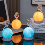 Astronaut figurines with glowing planets for science decor and educational display.