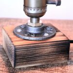 Miniature steam engine model on wooden base.