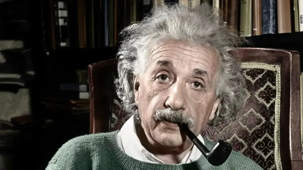 An image of Albert Einstein sitting in a study, holding a pipe in his mouth, surrounded by books and scientific memorabilia, showcasing his iconic appearance and intellectual environment.