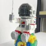 LEGO astronaut figure sitting on a colorful rainbow base, showcasing a creative science-themed decoration or educational toy.