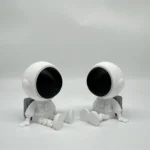 Cute astronaut figurines with large black visors, sitting on a plain white background.