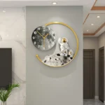 Modern wall clock featuring an astronaut figure on the moon with a black and white moon face and a gold circular frame, perfect for science-themed decor.