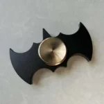 Unique bat-shaped metal object with a sleek black frame and a shiny silver center, perfect for science decor or educational displays.