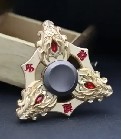 Decorative dragon-themed fidget spinner with intricate gold detailing and red gemstone accents, designed for stress relief and sensory stimulation.