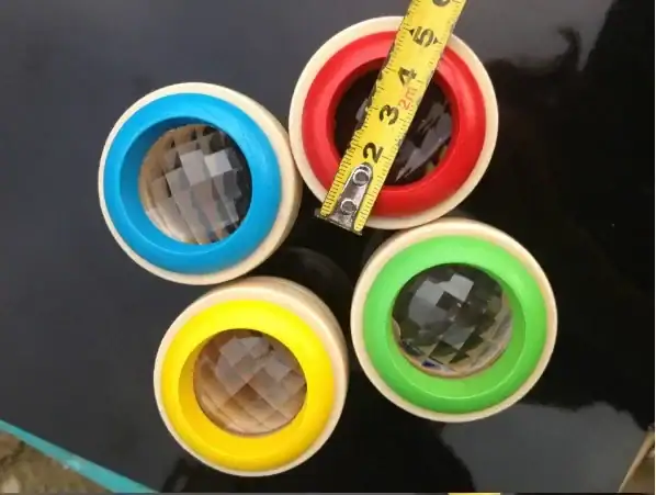 Colorful magnetic levitating globes with transparent spheres and vibrant rings, measuring approximately 2 inches in diameter.