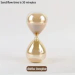 Golden hourglass sand timer demonstrating a 30-minute sand flow, showcasing a classic hourglass design with golden-colored sand.