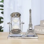 Decorative Eiffel Tower and vintage-style hourglass on a wooden desk, perfect for science-themed decor and educational spaces.