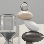 Elegant glass sculpture with smooth, rounded stones and a glass sphere on top, showcasing modern scientific decor.