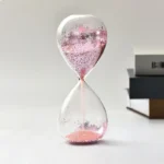 Sand timer with pink glitter for science experiments and educational decor. Perfect for classroom demonstrations, home science projects, or as a stylish desk accessory.