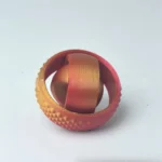 3D-printed geometric ring with textured surface and metallic finish, showcasing intricate design and craftsmanship. Perfect as a decorative science-inspired jewelry piece or educational model.