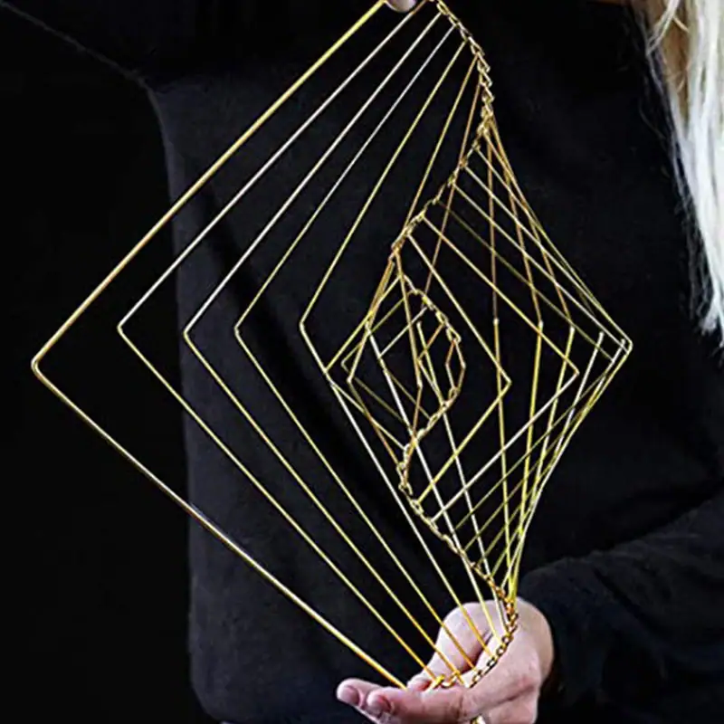 Geometric Wire Art Sculpture Intricate gold wire geometric sculpture held by a person against a dark background, showcasing modern abstract art design.