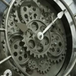 Close-up of a mechanical gear clock showcasing interconnected gears and white clock hands, emphasizing engineering and intricate design.