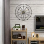 Stylish geometric wall clock with gold hands, mounted on a white brick wall, adding contemporary elegance to living room decor.