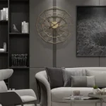 Geometric wall clock with gold frame and minimalist design, hanging on a gray wall in a contemporary living room setting.