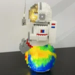 LEGO astronaut figure holding a flag, standing on a vibrant, rainbow-colored globe. Perfect for science decor and educational toys, showcasing creativity and space exploration themes.