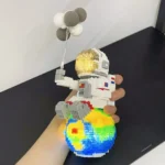 LEGO astronaut figure holding a balloon, standing on a colorful Earth-themed base, showcasing a creative science-themed toy.