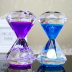 Elegant crystal hourglasses filled with vibrant purple and blue liquids, each containing a tiny bird figurine, perfect for educational decor or as a unique gift.
