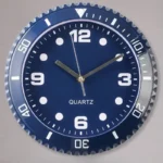 Quartz wall clock with a blue face, white numerals, and a silver bezel, featuring hour, minute, and second hands for precise timekeeping.
