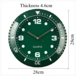 Analog wall clock with green face, white hour markers, and black hands, suitable for educational or decorative purposes.