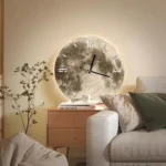 Stylish wall clock featuring a moon surface design, illuminated with soft backlighting, hanging above a cozy beige sofa in a contemporary living room.