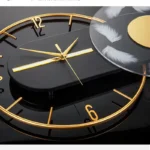 Elegant black and gold wall clock featuring feather accents for a stylish home decor piece. Perfect for adding a touch of sophistication and educational charm to any room.
