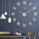 Stylish modern wall clock with Roman numerals on a dark blue wall, complemented by minimalist pendant lights and a sleek dining table setup.