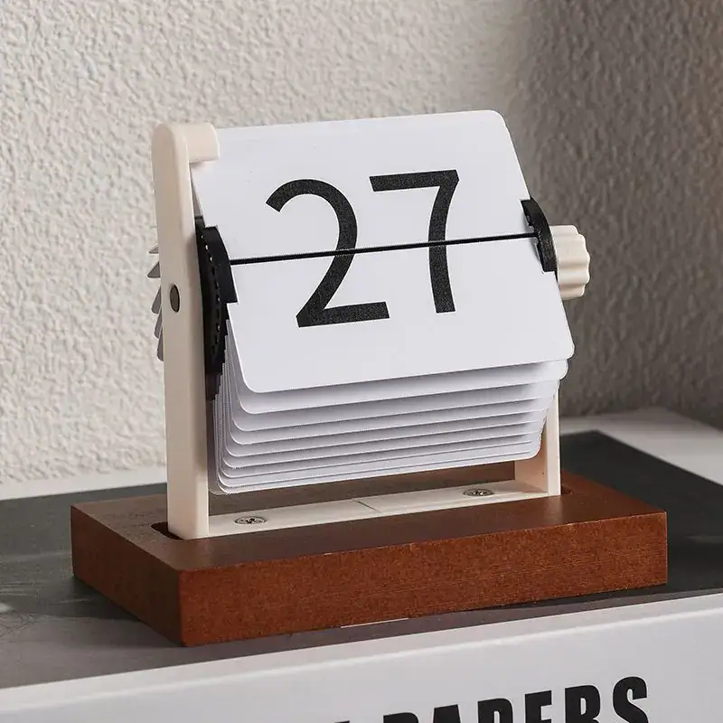 Flip Clock Calendar with Wooden Base and Number Flaps Vintage flip clock calendar with wooden base displaying the number 27, showcasing a retro design for educational or decorative use.
