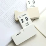 Close-up of a white calendar flip clock showing January 10, with a focus on the date display and the flip mechanism.