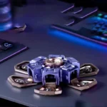 Small hexapod robot toy with multiple legs, designed for science education and STEM learning, placed on a dark surface with electronic components in the background.