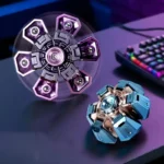 Two metallic fidget spinners with intricate design, one purple and one blue, placed on a dark surface with a colorful keyboard in the background.
