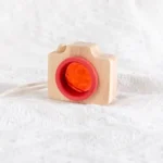 Wooden camera toy with orange ball for kids, educational and sensory play, perfect for science and learning activities.