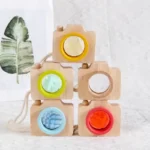 Wooden camera toy with colorful dials and lenses, perfect for educational play and developing fine motor skills in children.