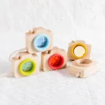 Wooden camera toy with colorful lenses for kids, educational and playful.