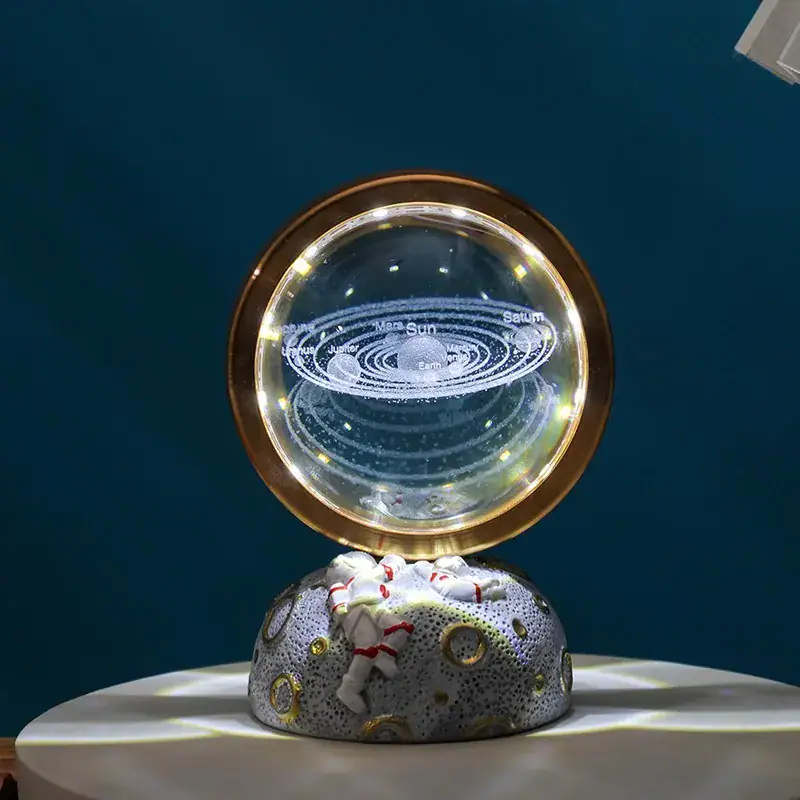 Decorative galaxy lamp featuring a miniature astronaut figure on a textured base, with a solar system design illuminated inside, perfect for science-themed decor and educational purposes.