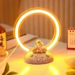 Illuminated neon ring with a small figurine of a girl riding a bicycle, placed on a textured base with scientific symbols, glowing warmly in a cozy indoor setting.