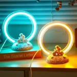 Neon light science decor with astronaut figurines on moon-like bases, featuring glowing rings in blue and yellow for educational and decorative purposes.