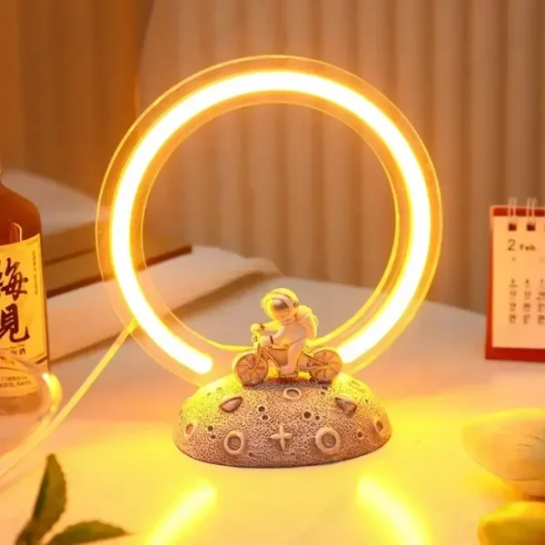 Illuminated neon ring with a small figurine of a girl riding a bicycle, placed on a textured base with scientific symbols, glowing warmly in a cozy indoor setting.