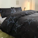 Starry night galaxy themed bedding with star and comet patterns in blue and white on black background.
