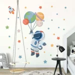 Space-themed wall sticker featuring an astronaut holding planets and a rocket, perfect for children's bedrooms or playrooms.