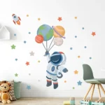 Space-themed wall decal featuring an astronaut holding planets and a rocket, perfect for children's rooms and educational decor.