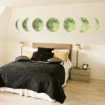 Artistic wall decor featuring the different phases of the moon above a modern bedroom bed, creating a celestial and calming atmosphere.